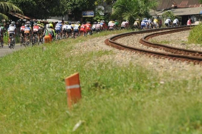 The peloton passes a rail line
