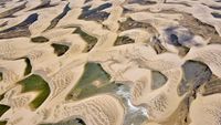Aerial view of sand dunes and lagoons in Brazil's Lençóis Maranhenses National Park.