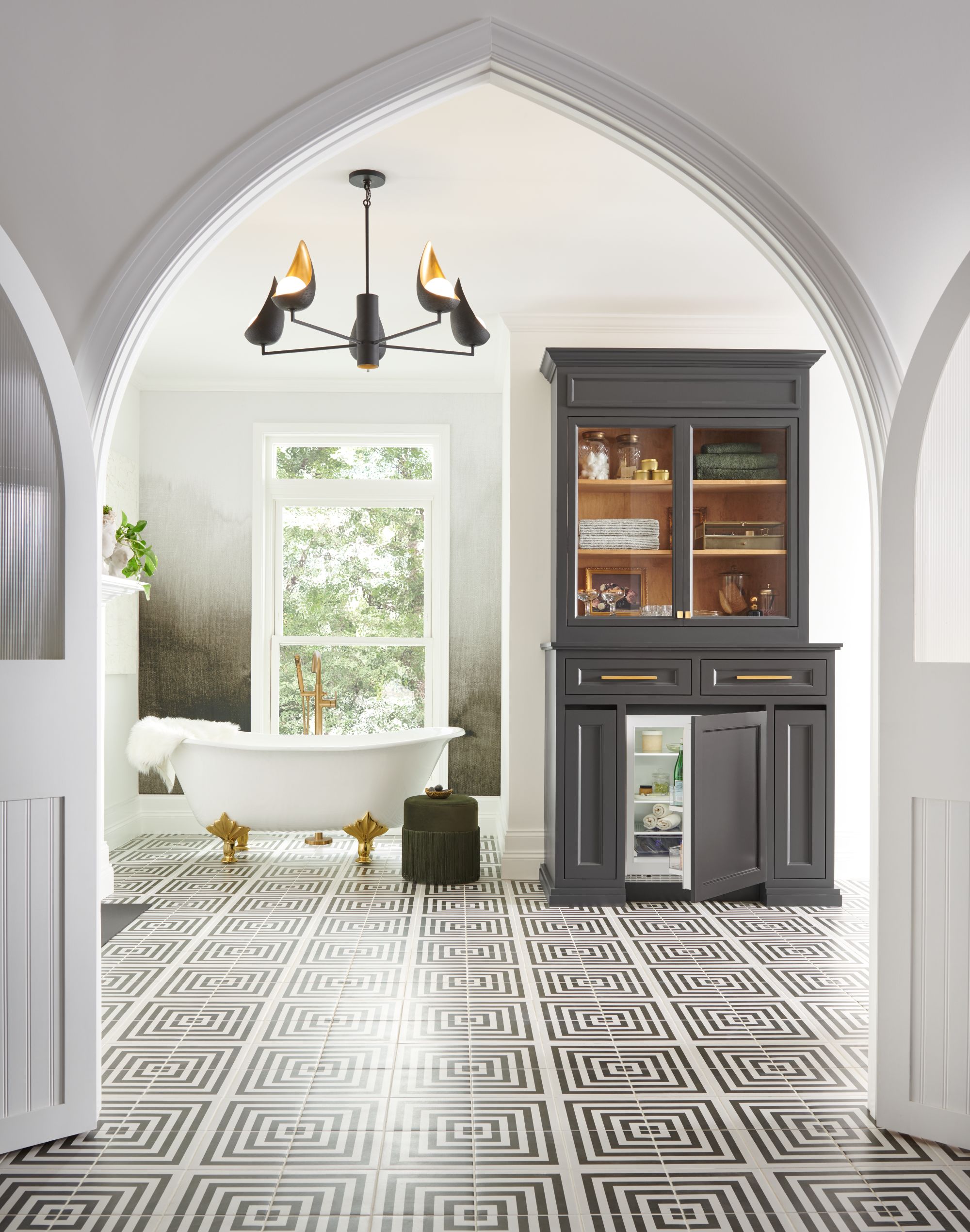 grand bathroom with tiled floors, a freestanding tub and a small undercounter fridge