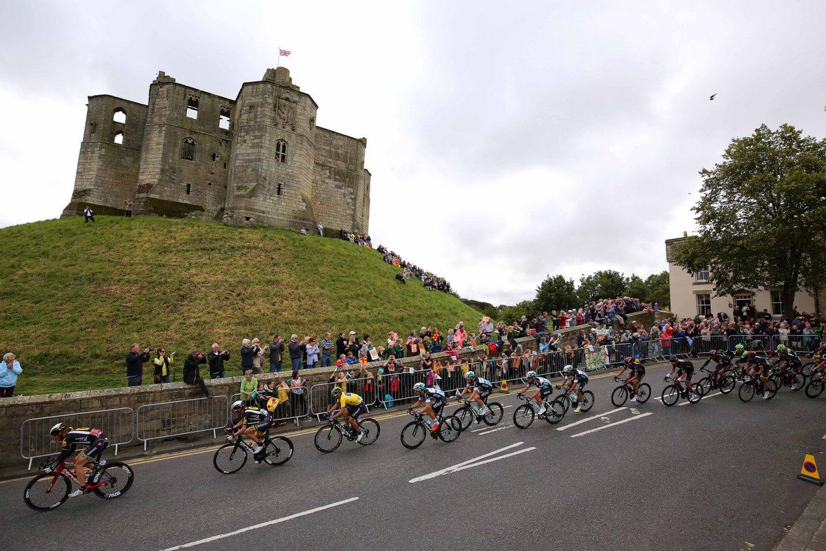 The peloton riding past a castle