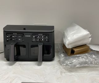 Cosori Dual Drawer Air Fryer with packaging on the left