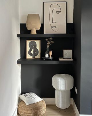 Grey alcove shelving with neutral decor including a paper lamp and sketched artwork