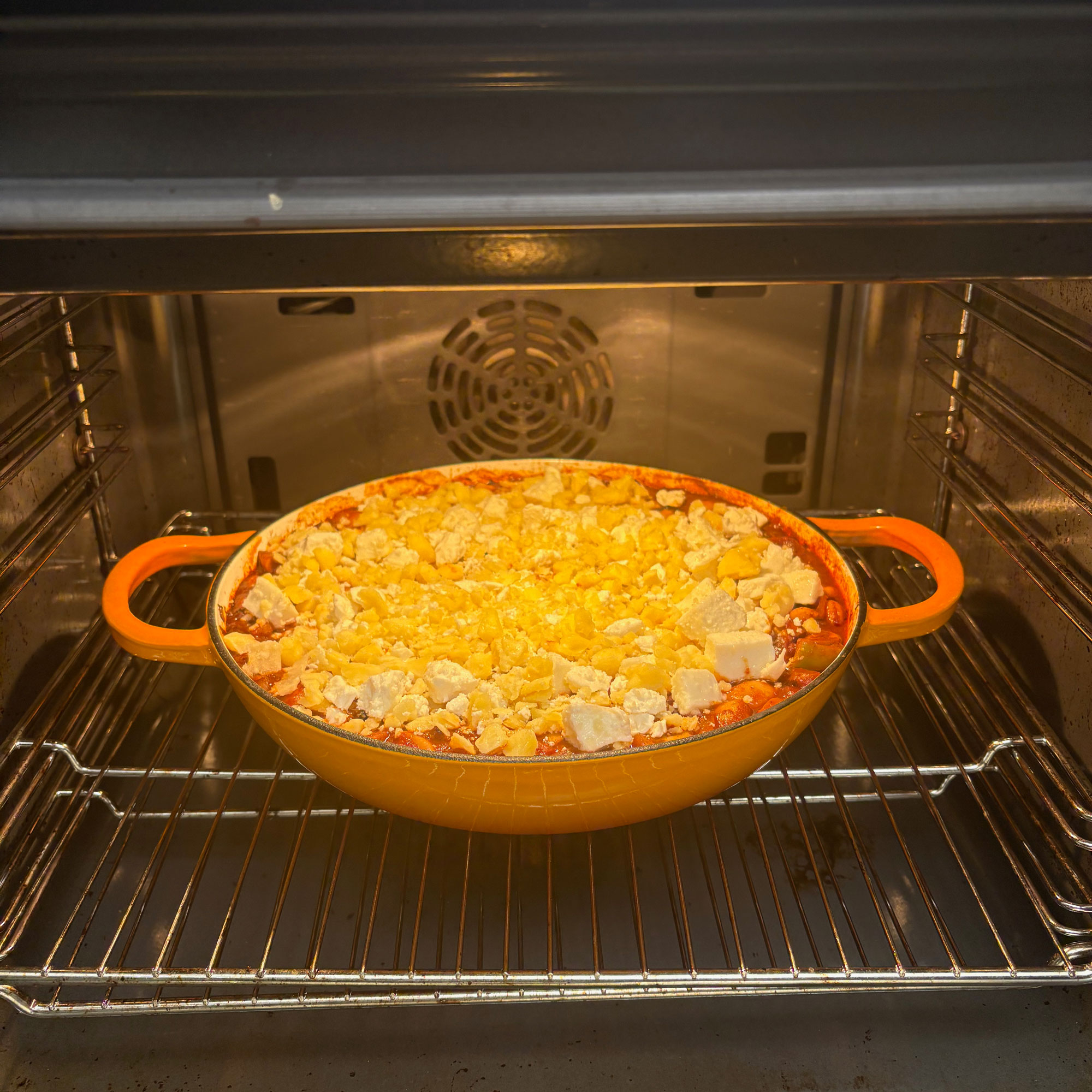 Orange cast iron pan in oven