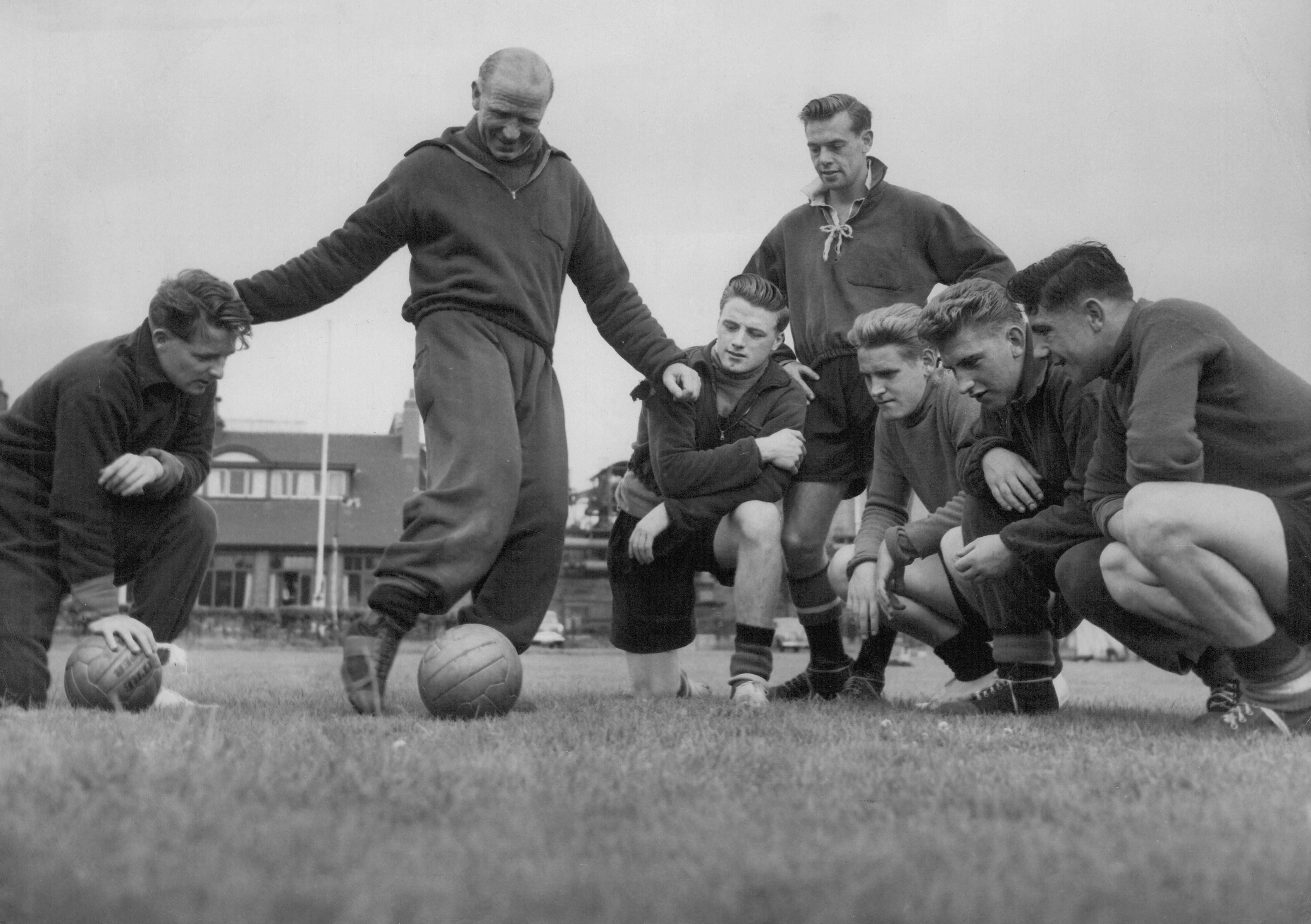 Manchester United manager Matt Busby coaches his players during a training session, 1956