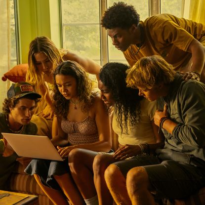 (l-r) Chase Stokes as John B, Madelyn Cline as Sarah Cameron, Madison Bailey as Kiara, Carlacia Grant as Cleo, Jonathan Daviss as Pope, Rudy Pankow as JJ, crowded around a laptop, in episode 401 of Outer Banks.