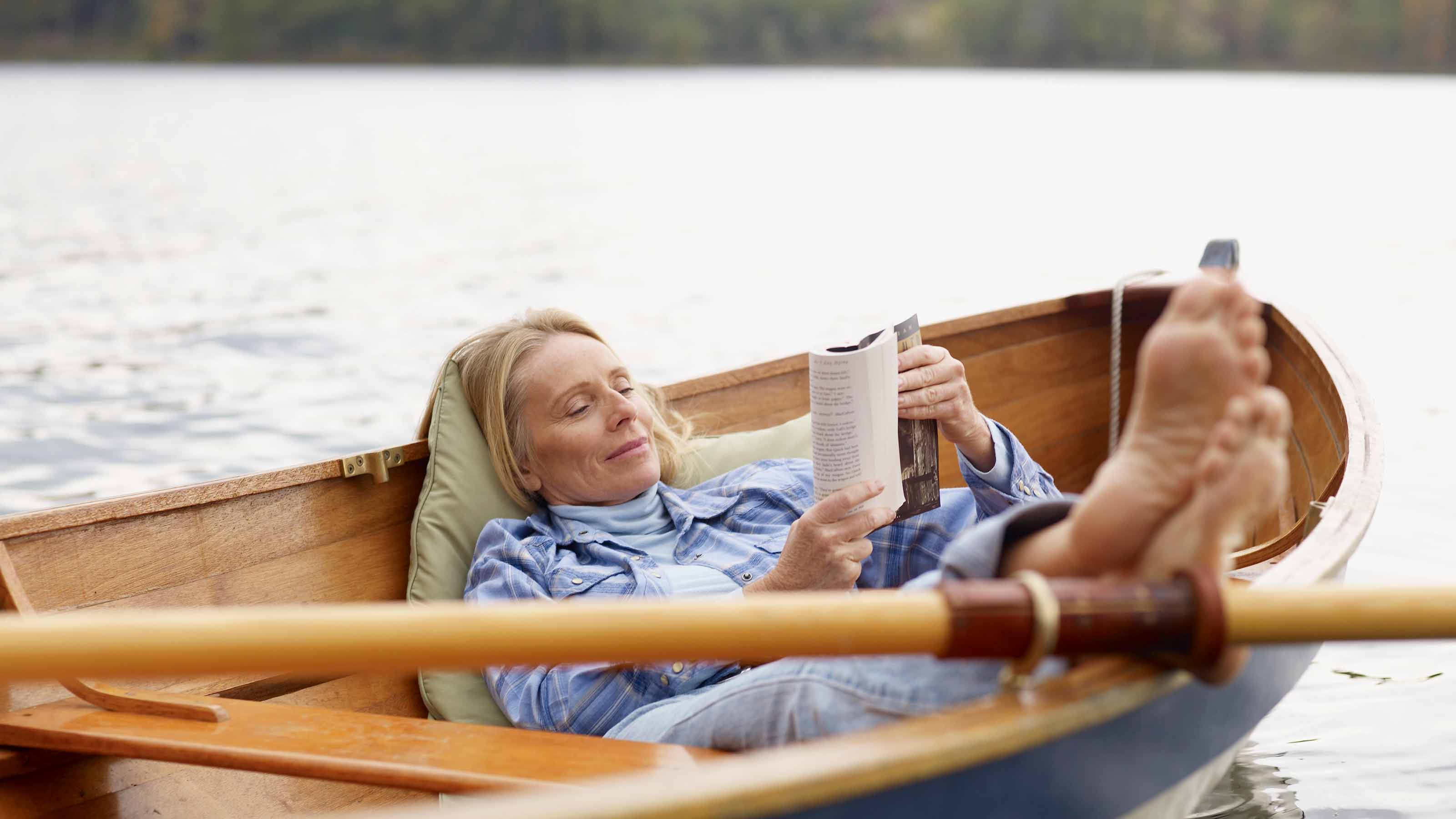 Woman Reading and Relaxing in Rowboat