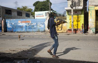 A civilian takes up arms against gang members in Port-au-Prince.