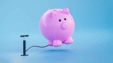 A tire pump appears to be pumping air into a growing piggy bank.