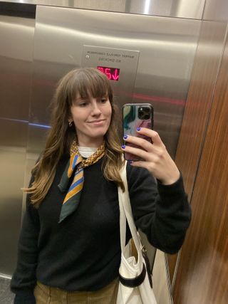 editor Halie LeSavage takes a selfie in an elevator mirror displaying her hair curled with socks