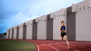 Athlete running on a track wearing the Garmin Forerunner 945