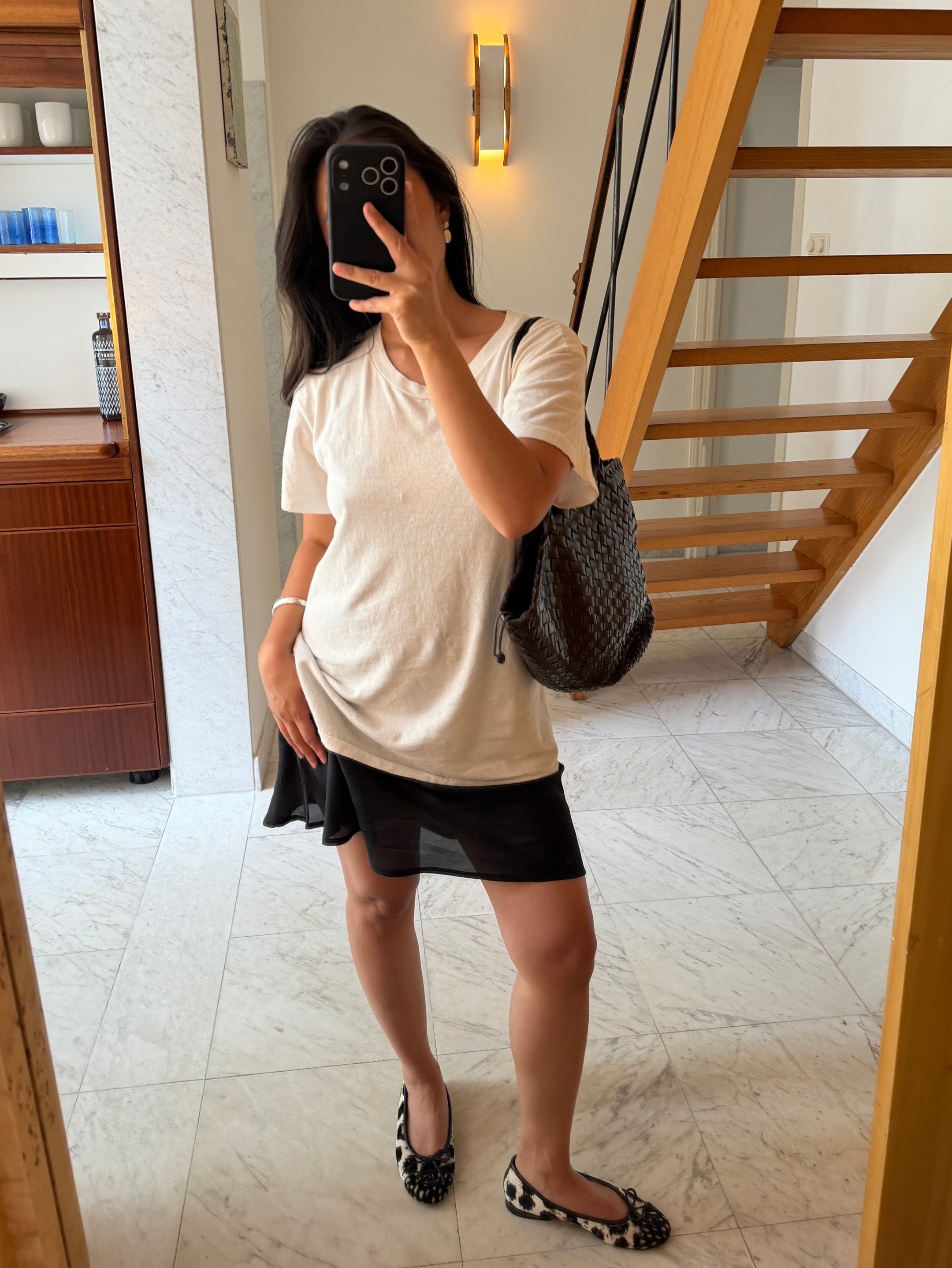 Jordan Risa wearing a white t-shirt with sheer black skirt and ballet flats.