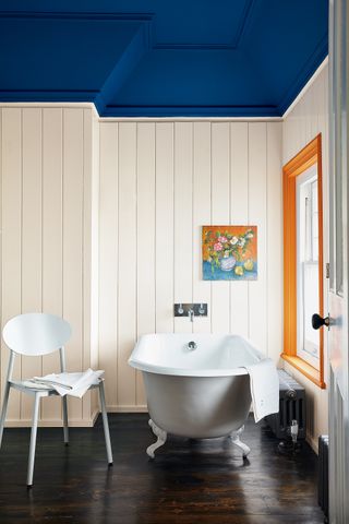 White panelled bathroom with blue ceiling