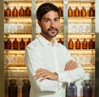 Ricardo Vila Nova standing in front of his tailored treatment bottles.