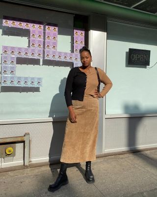 @champagnemani  wears a tan suede skirt with a block colour cardigan and chunky boots