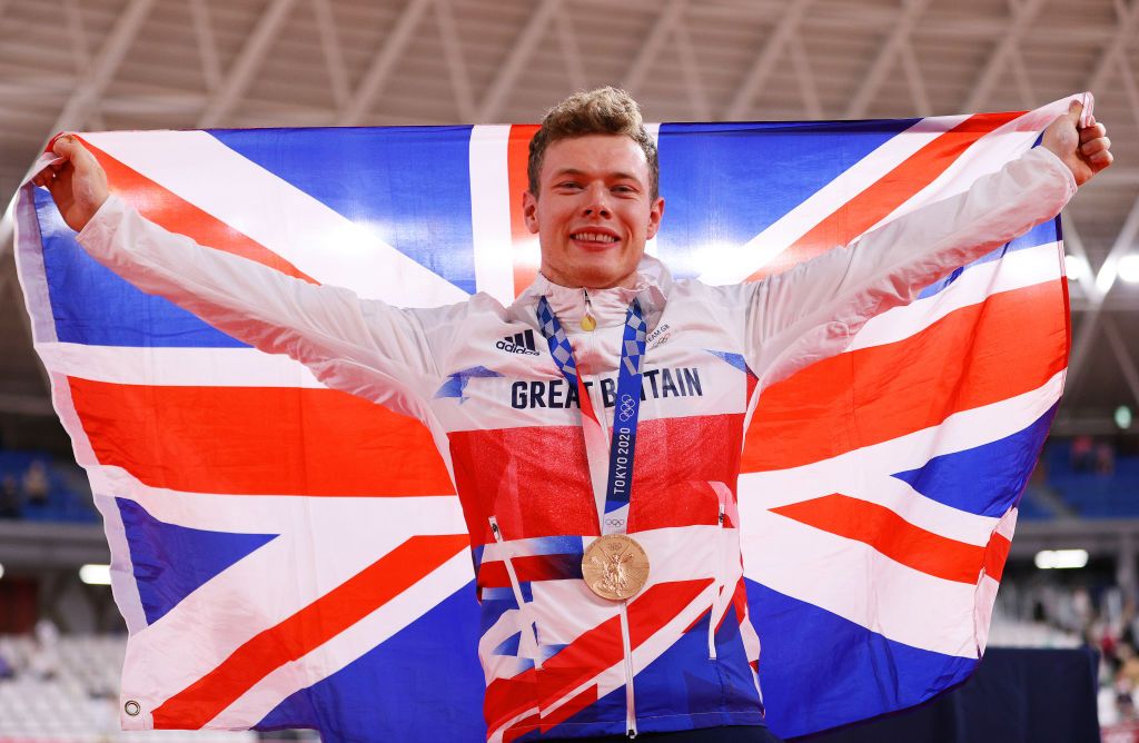 IZU JAPAN AUGUST 06 Bronze medalist Jack Carlin of Team Great Britain poses on the podium and while holding the flag of they country during the medal ceremony after the Mens sprint finals of the track cycling on day fourteen of the Tokyo 2020 Olympic Games at Izu Velodrome on August 06 2021 in Izu Japan Photo by Tim de WaeleGetty Images