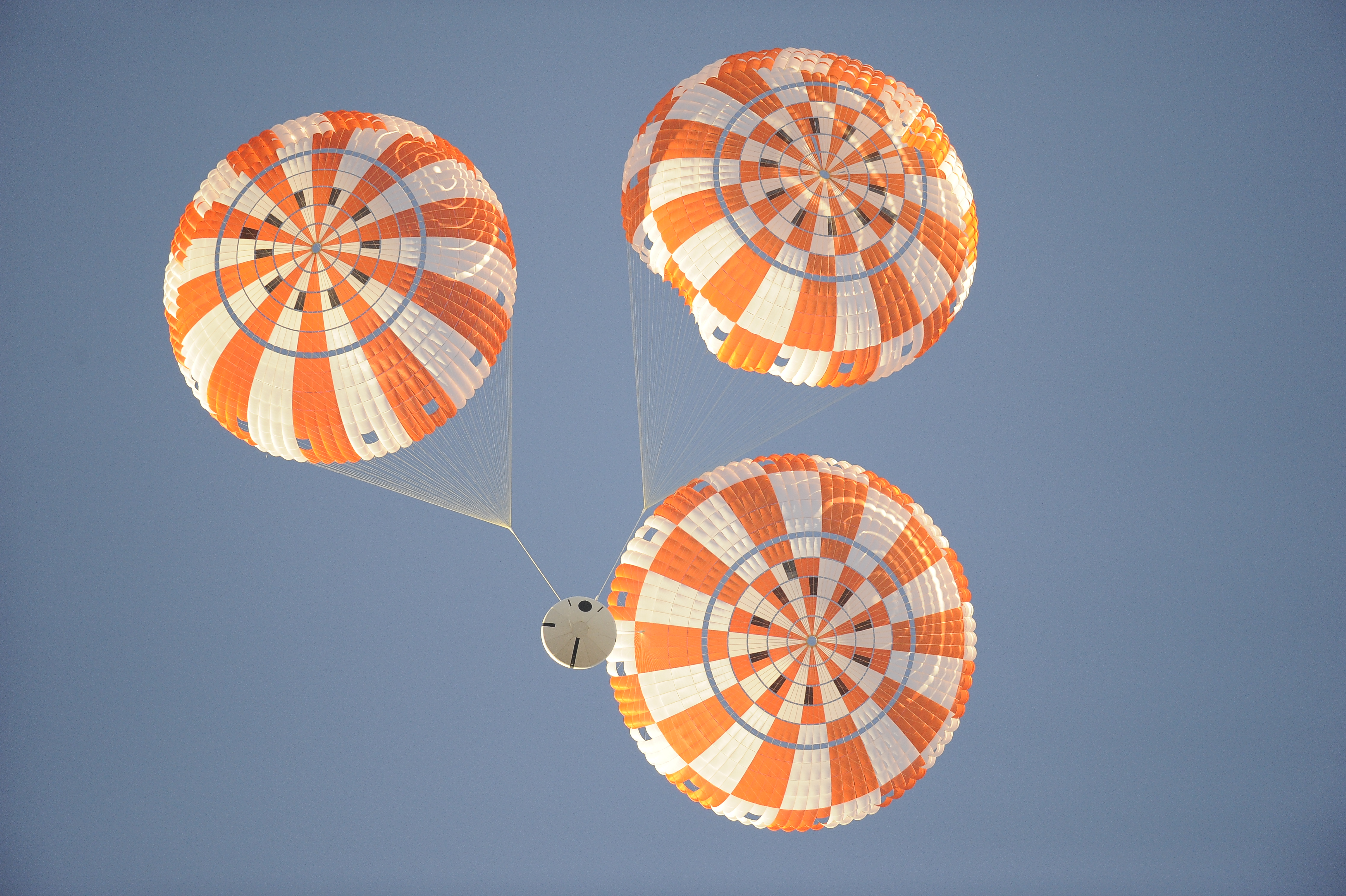 three parachutes visible above spacecraft