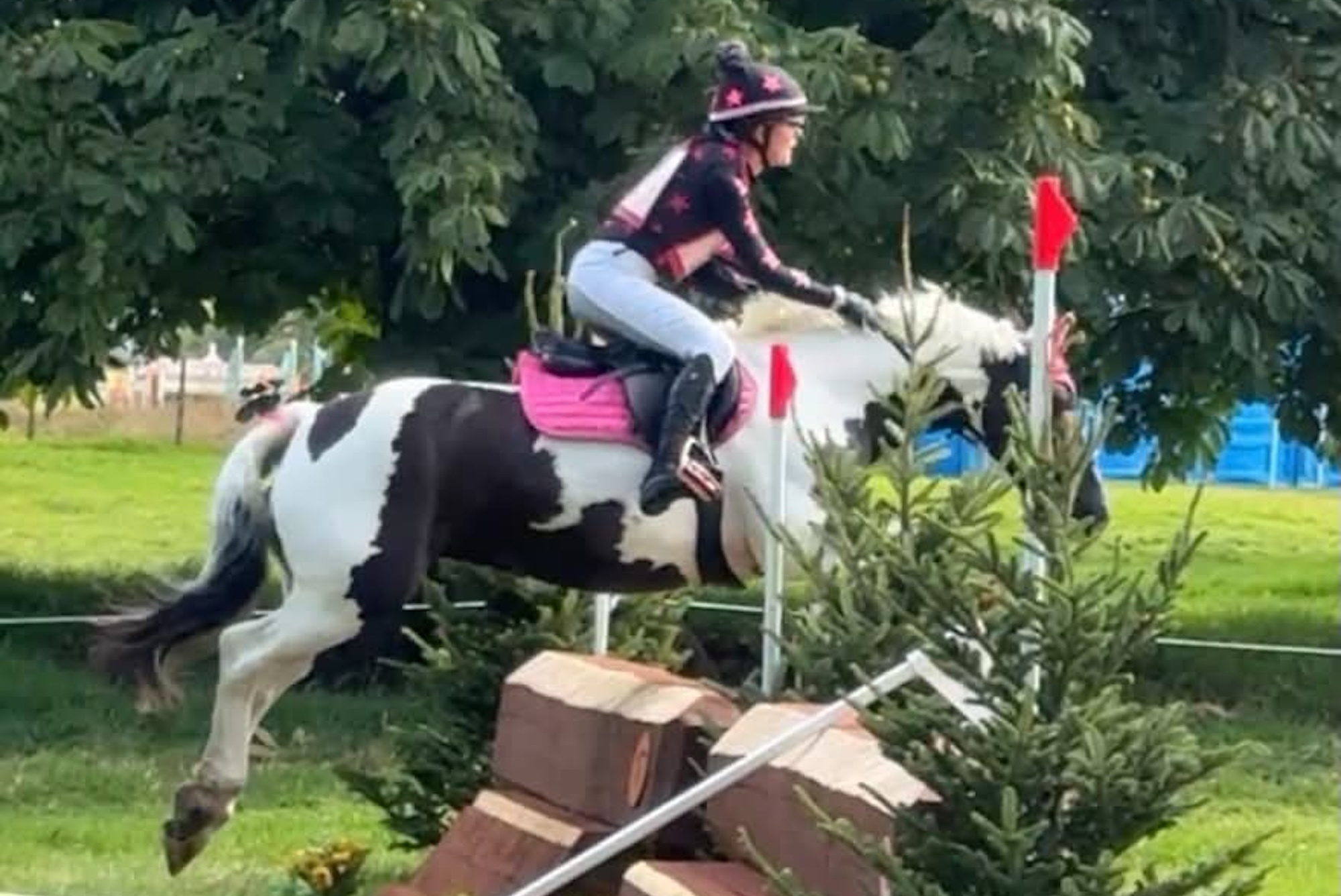 Hope Wilson and piebald cob Charlie Girl jump a cross-country fence