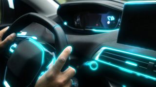 Interior of a smart car. It is lit up with teal LED lights