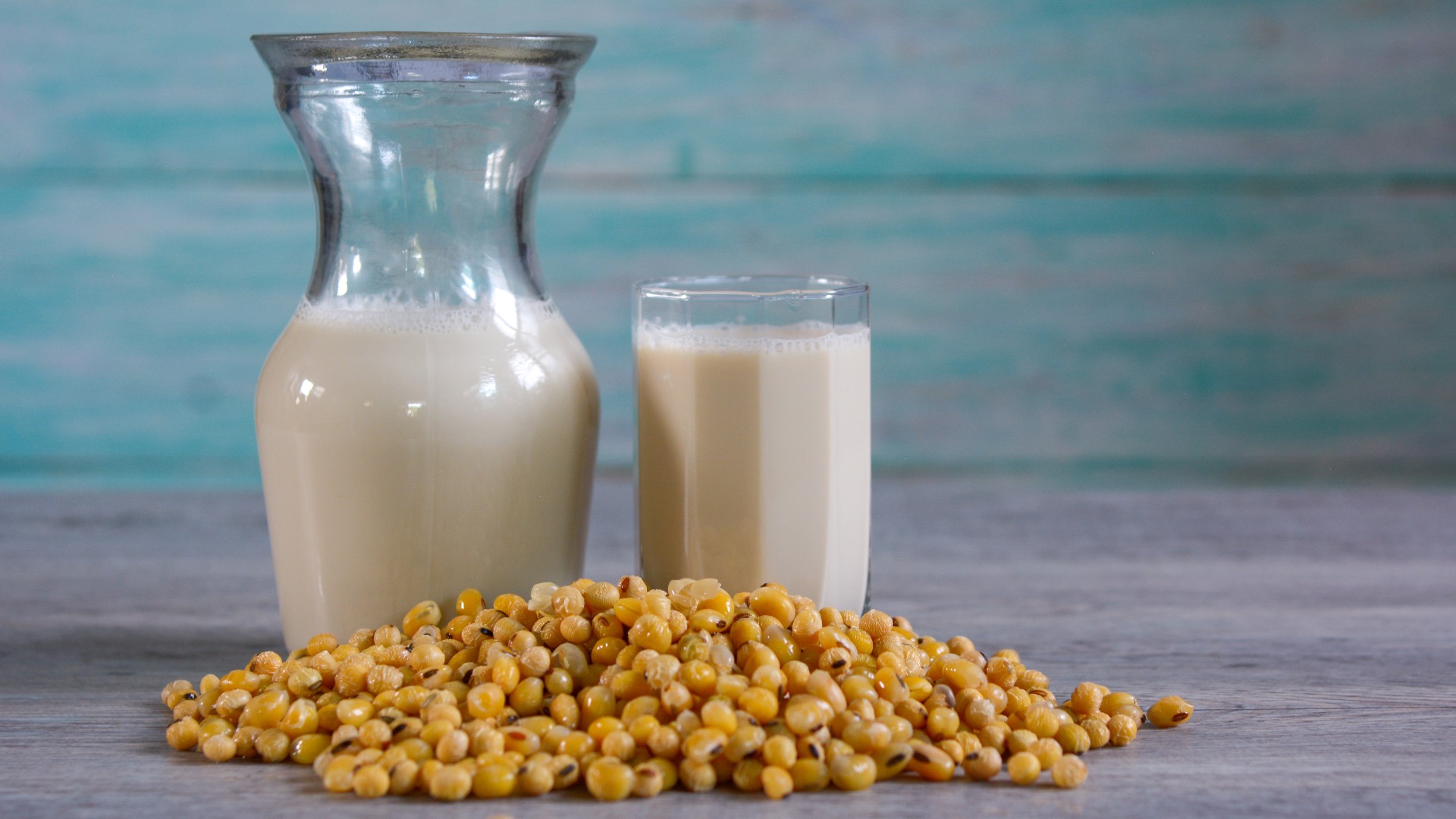 Soy milk in a bottle and glass with soybeans on top