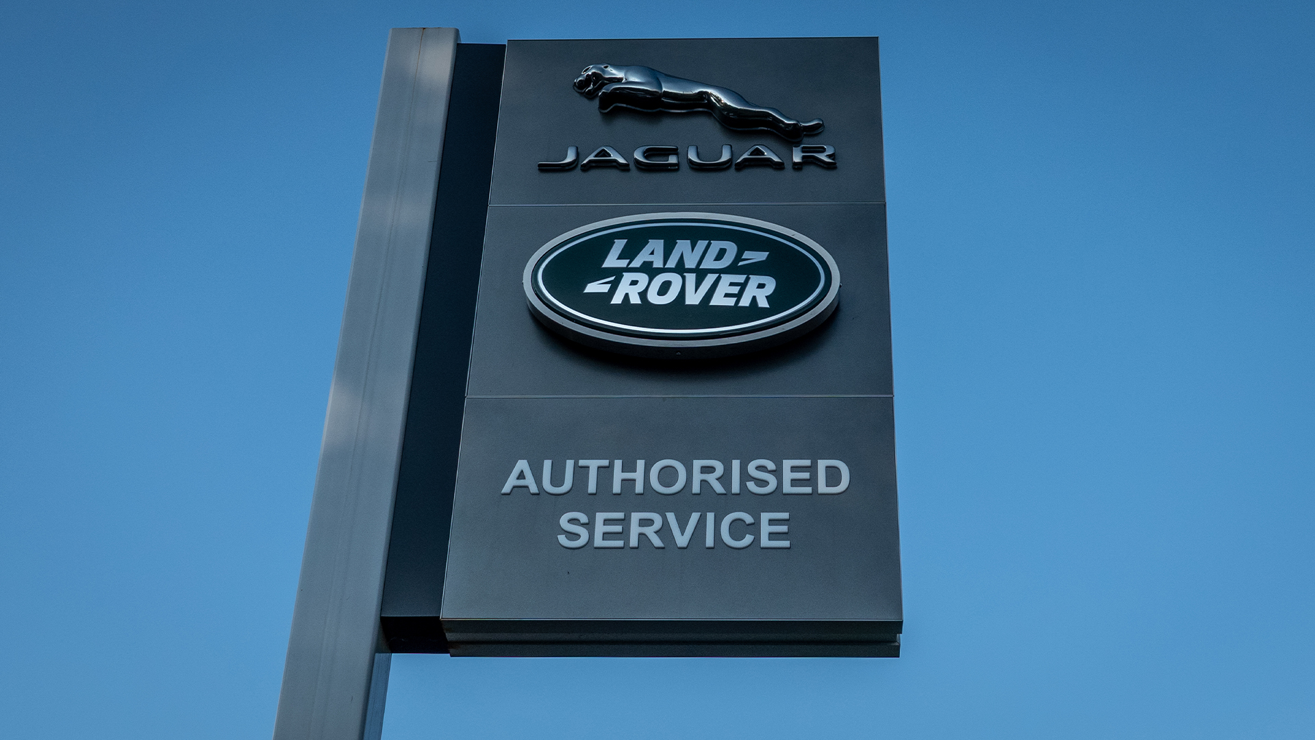 Jaguar Land Rover dealership sign in Taunton, Somerset, featuring Jaguar logo and Land Rover logo.