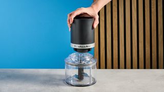 KitchenAid Cordless Top Down Food Chopper photographed in front of a blue background.