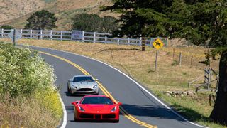 two sports cars driving on a winding road in napa valley