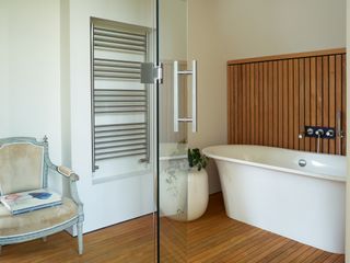 bathroom with white bath and wood panelling