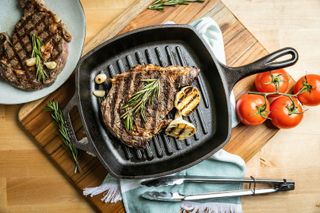 Lodge Cast Iron Pan with a steak and some garlic in it