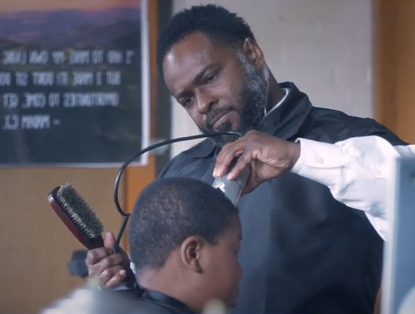 Terrance Newton cuts a student's hair.