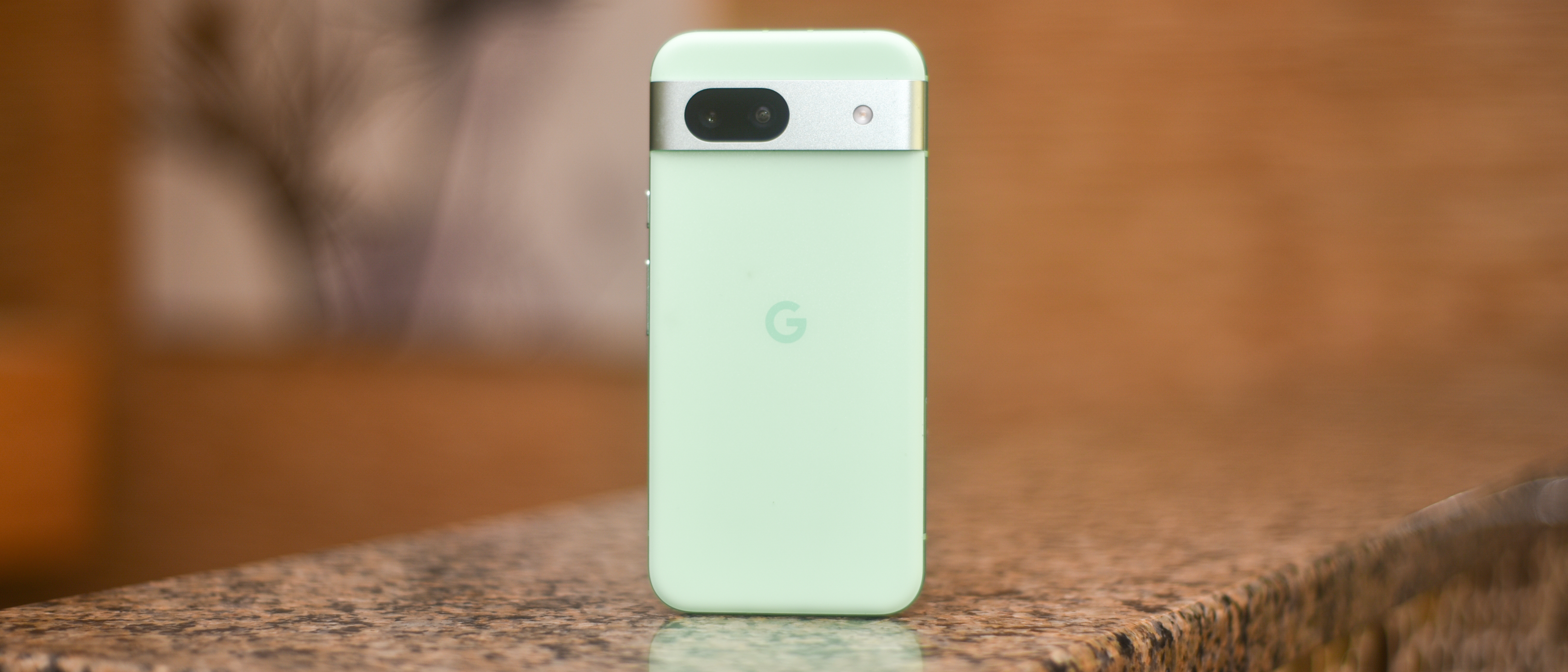 Google Pixel 8a in aloe green sitting on marble counter