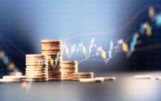Coin stacks before blue financial graph representing low-cost index fund investing