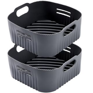 Two dark gray air fryer basket shaped silicone liners pictured one above the other on a white background