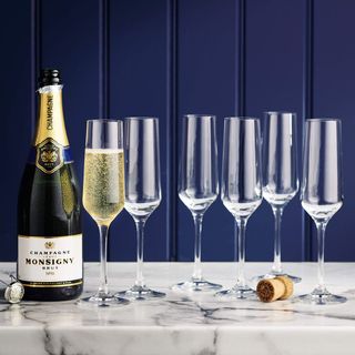 Aldi champagne glasses on a table with a bottle of champagne