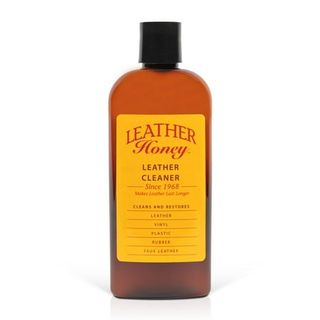 A brown plastic bottle Leather Honey Non-Toxic Leather Cleaner, 8 Oz, with black cap and yellow and red label