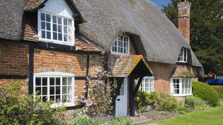 pretty thatched cottage with bricks and half timbers