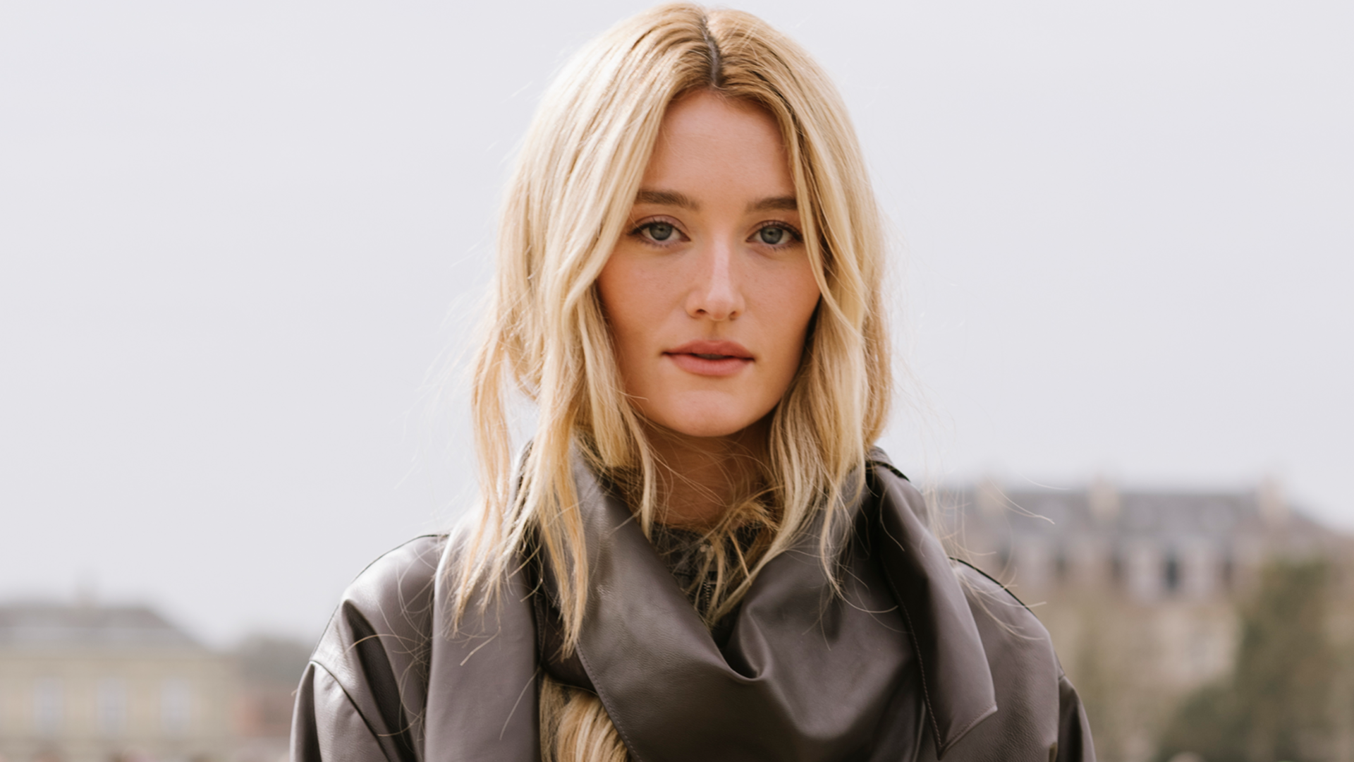 Sarah Pidgeon attended the Loewe Fall 2026 show in a brown leather version of the scarf coat trend