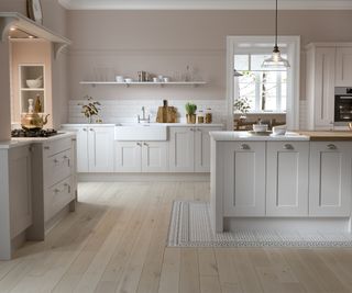 A newly installed shaker style kitchen with light-coloured cabinets and light wood floors