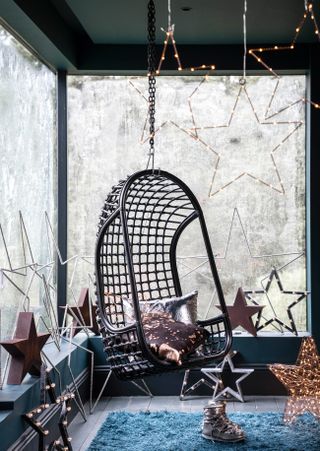Hanging chair in a window with light up stars