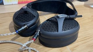 Meze Audio Empyrean II open-back headphones lying flat showing cable connections