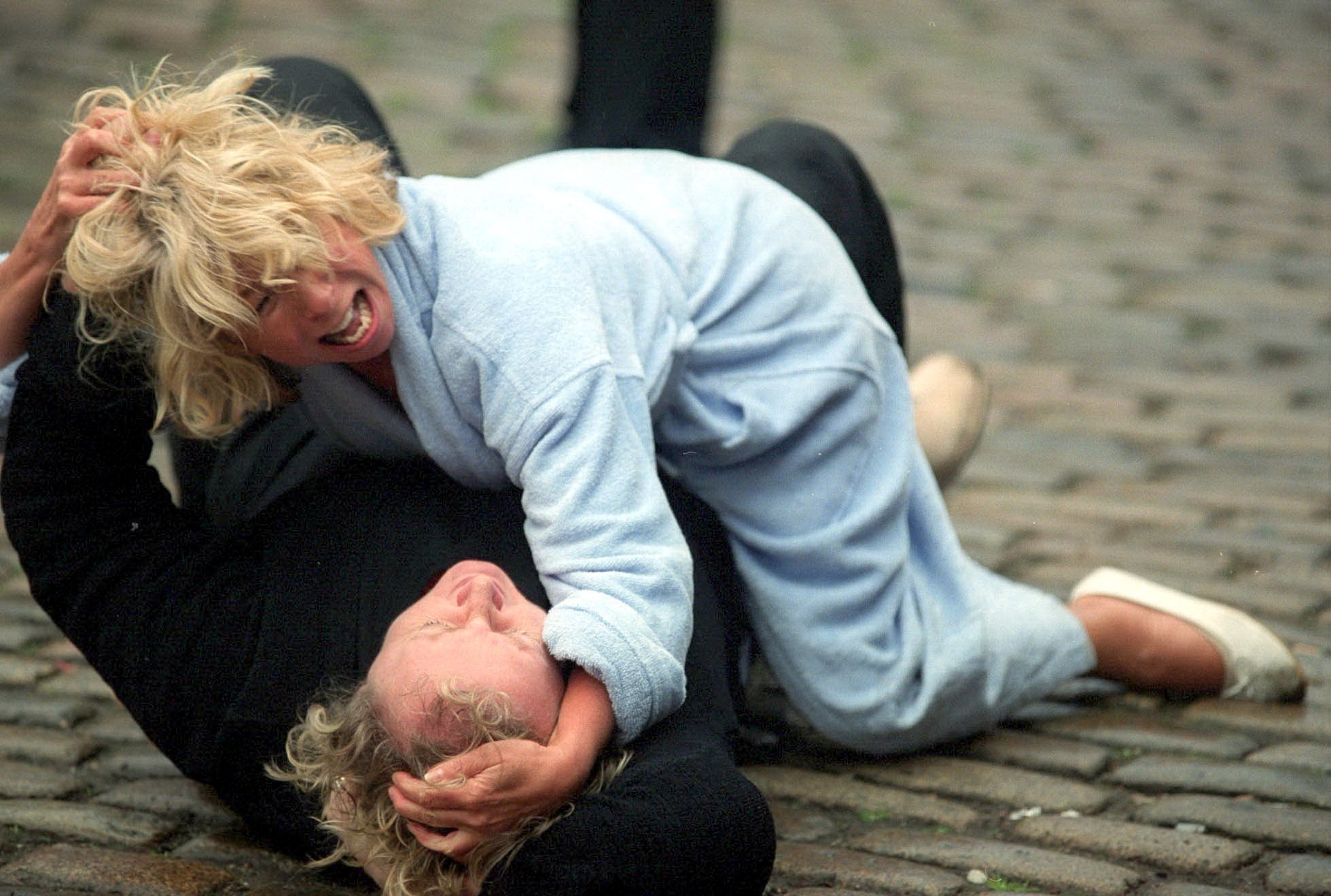 Gail on top of Eileen while pulling each other's hair on the cobbles in Coronation Street
