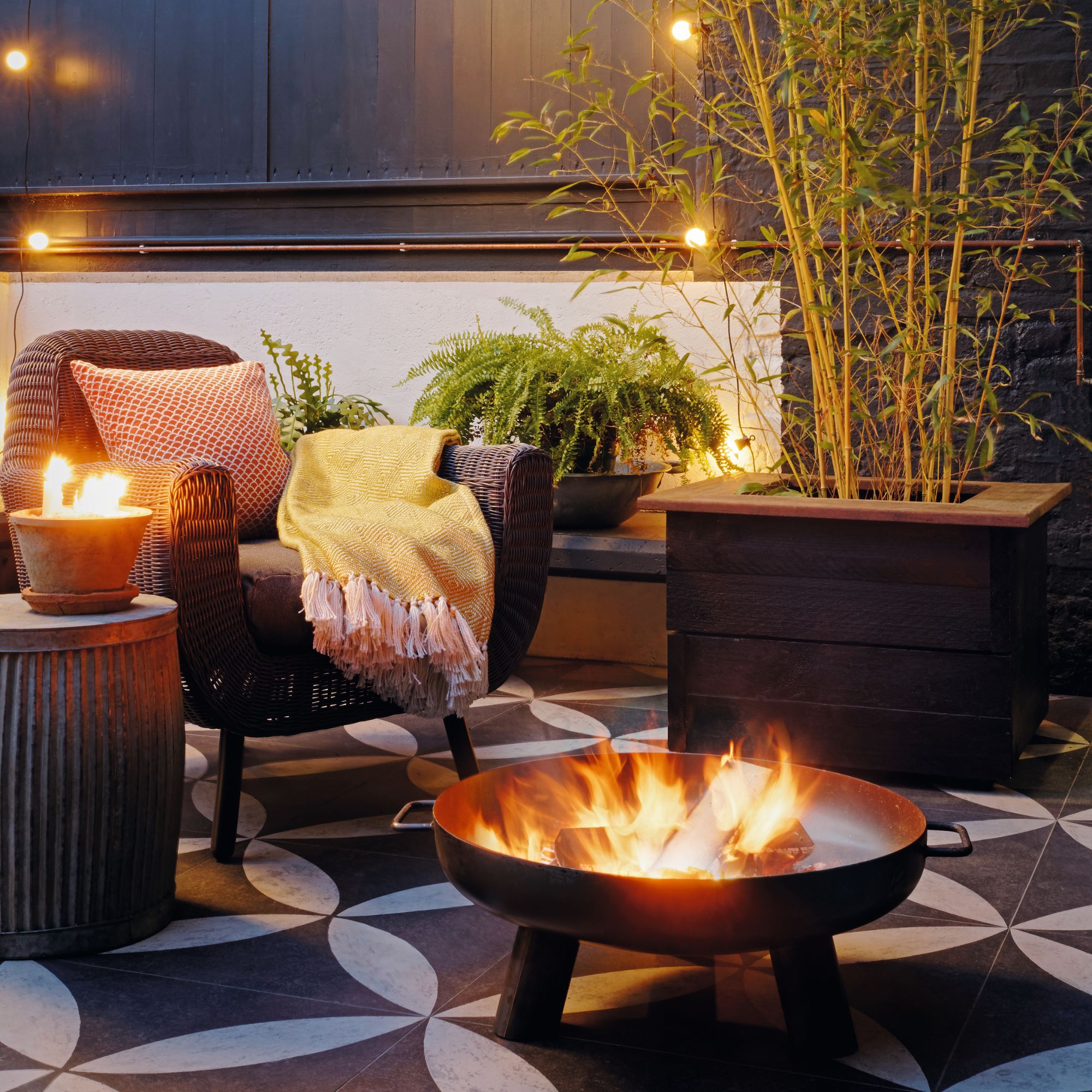 outdoor seating area in garden with tiled floor and firepit
