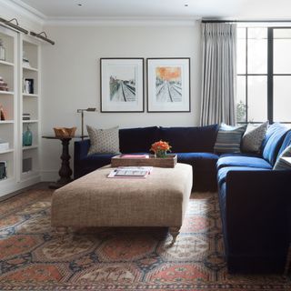 white living room with blue sofa and large bespoke ottoman