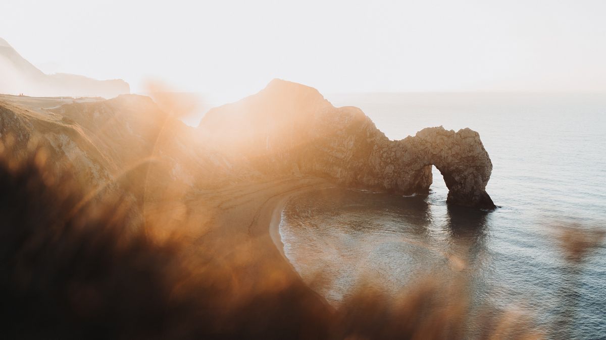 Famous landscape Durdle Door showcased with foregorund detail while shooting against the sun