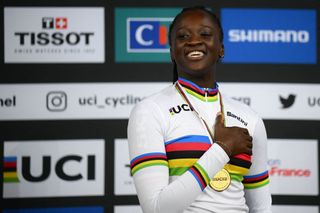France's Marie Divine Kouame celebrates on the podium with her gold medal and rainbow jersey after winning the world title in the Women's 500m time trial final during the UCI Track Cycling World Championships