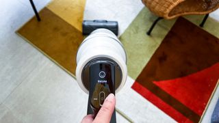 Hand holding the Samsung Bespoke Jet AI cordless vacuum as it begins its initial setup