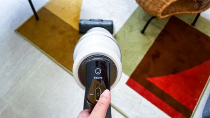 Hand holding the Samsung Bespoke Jet AI cordless vacuum as it begins its initial setup