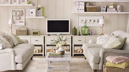 Neutral living room with cream facing sofas and a tv on a shelving unit