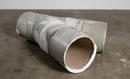 A three-way concrete pipe lying on its side