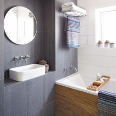 bathroom with black and white tile and bath tub