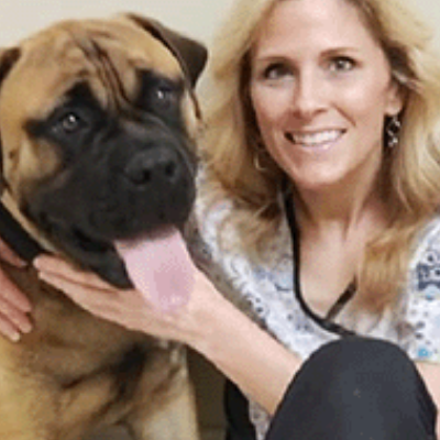 Vet Dr Beth turning smiling with a dog